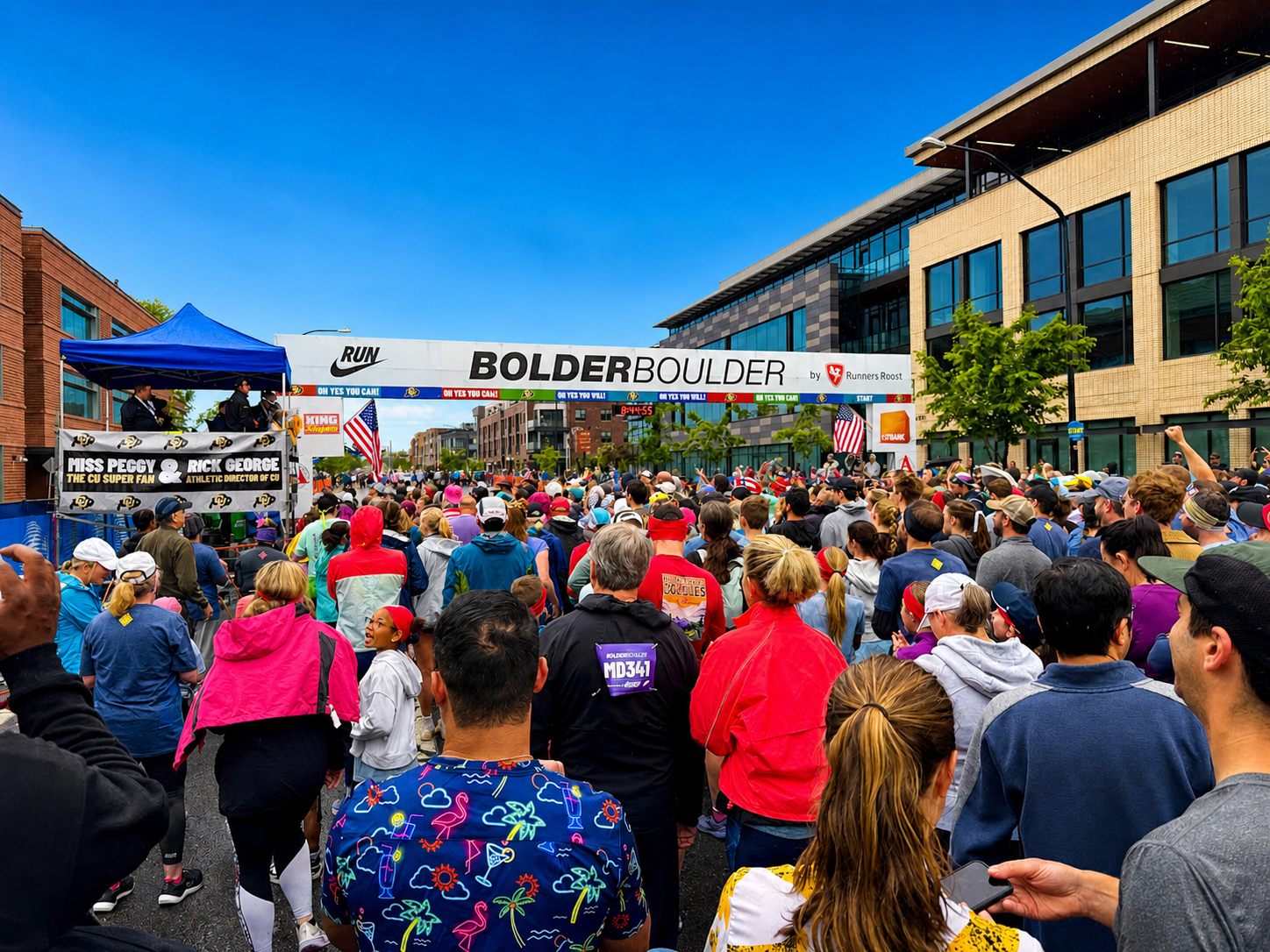 Crowd of runners under the sponsor-branded start gantry at the BolderBOULDER 10K
